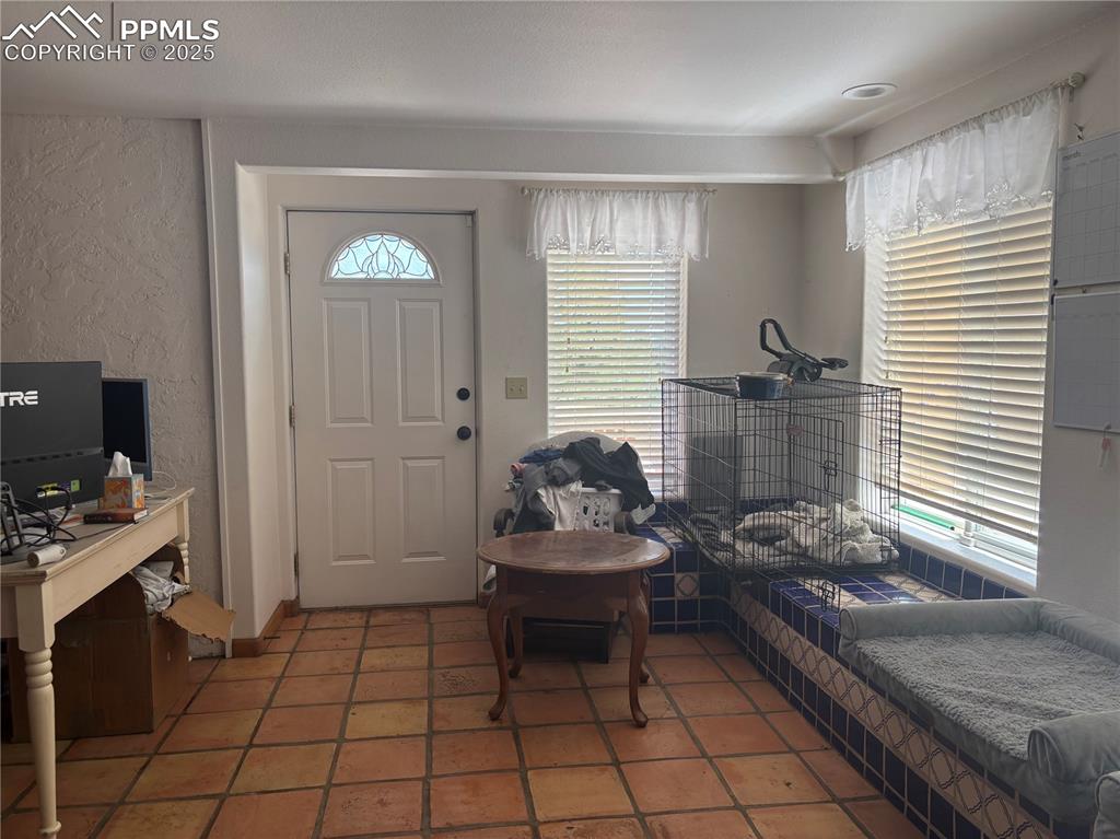Image 2 of 25: Entryway featuring a textured wall and light tile patterned floors