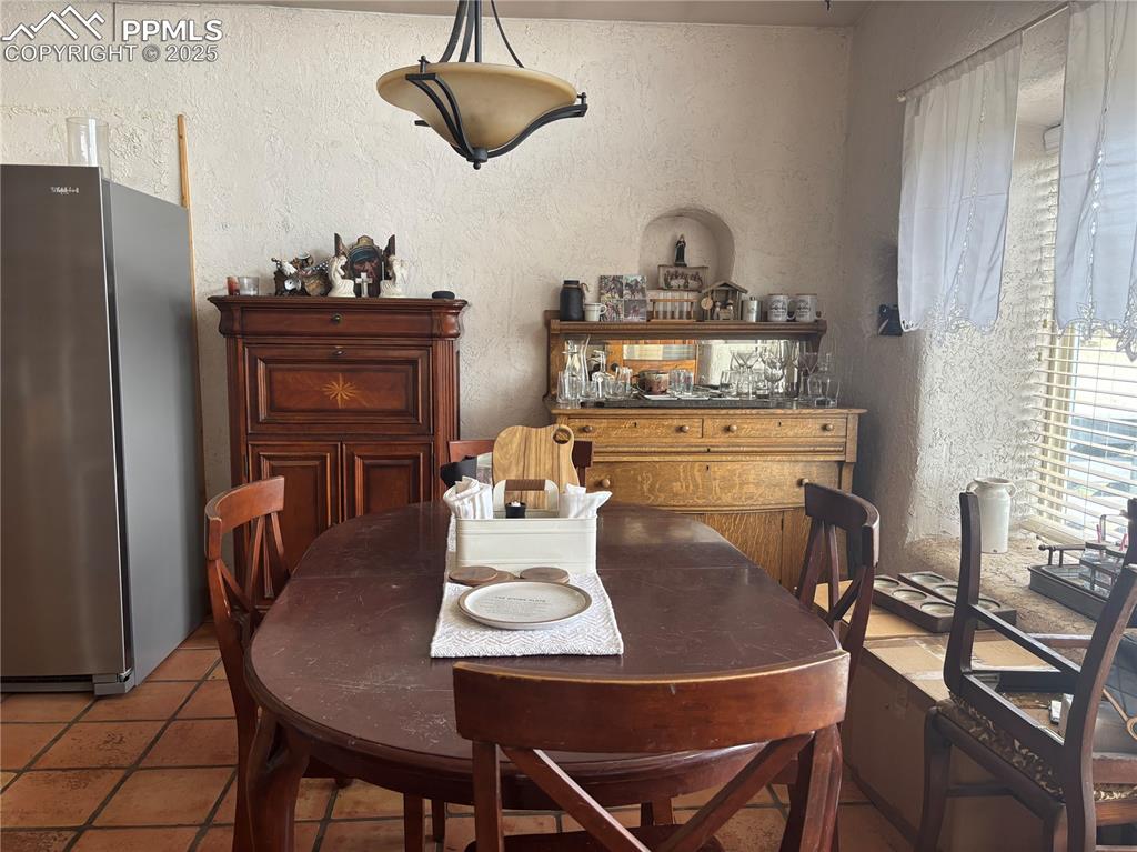 Image 4 of 25: Dining space with a textured wall and tile patterned floors