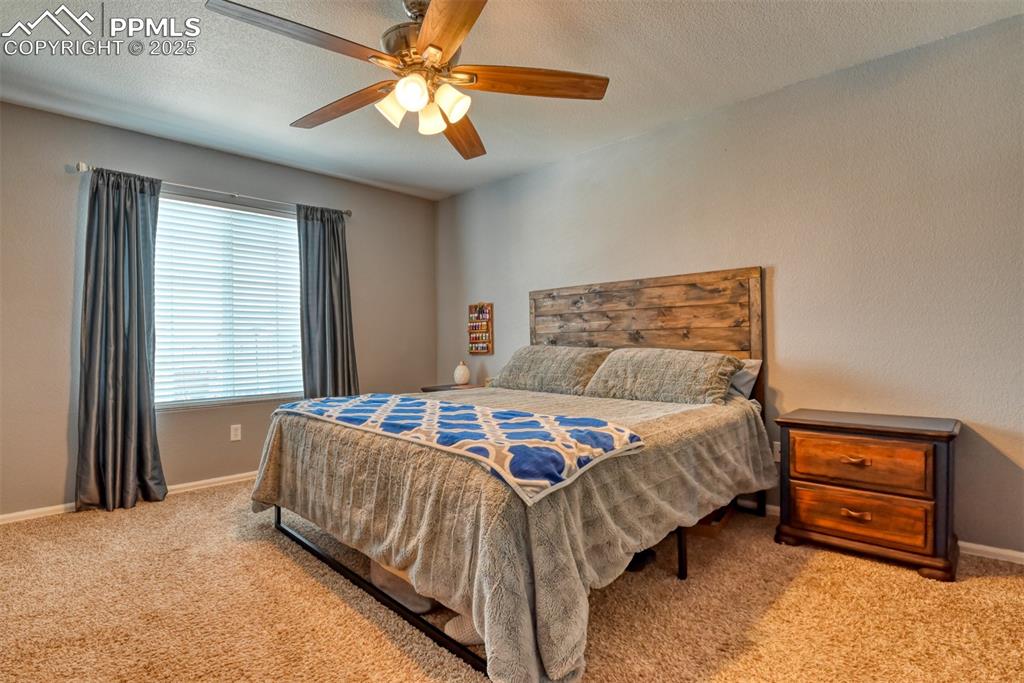 Image 18 of 42: Carpeted bedroom featuring ceiling fan and a textured ceiling
