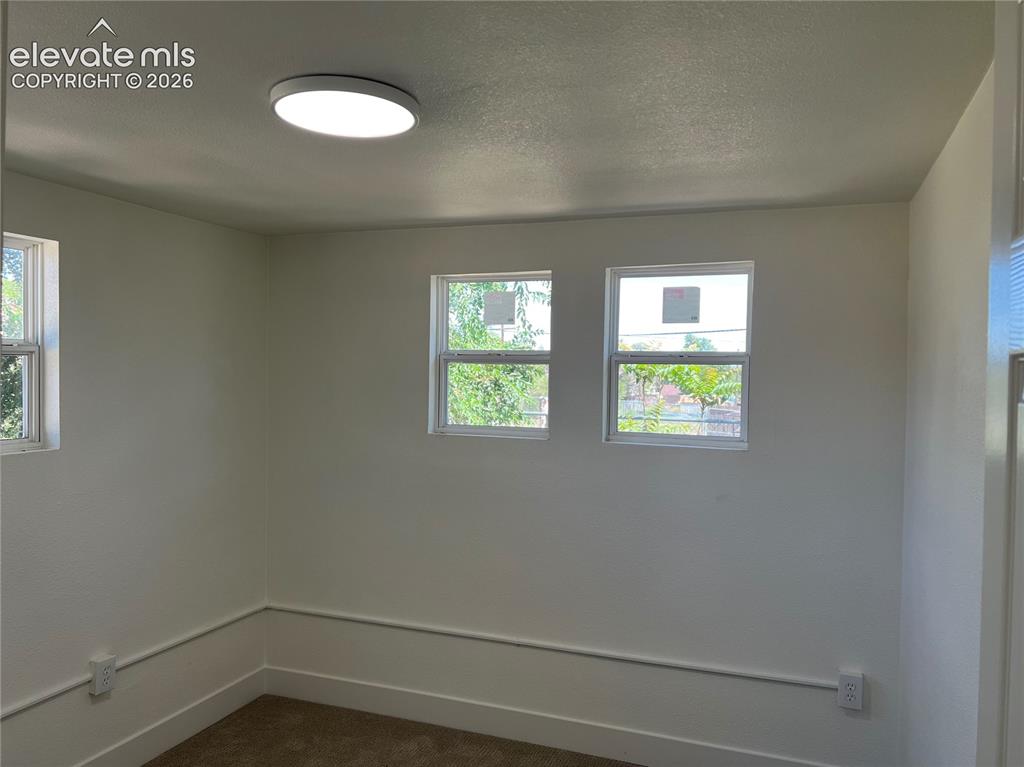 Image 10 of 23: Main House Bedroom #3 - Bright corner room with dual windows featuring natu