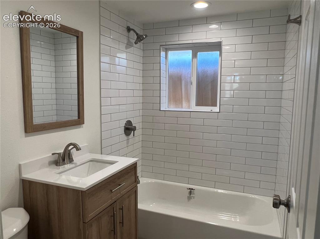 Image 20 of 23: Cottage Bathroom with white subway tile surround, recessed lighting, wood-f