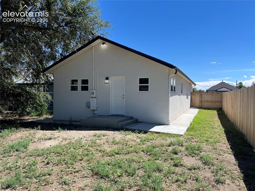 Image 21 of 23: Single-story residence featuring a clean white exterior with black trim acc