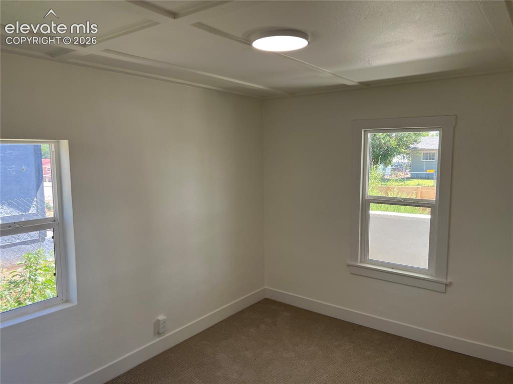 Image 8 of 23: Main House Bedroom #1 - Bright corner room with dual windows featuring natu