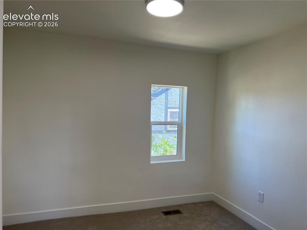 Image 9 of 23: Main House Bedroom #2 - Bright corner room with dual windows featuring natu