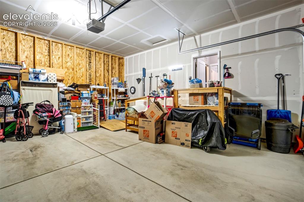 Image 30 of 43: 2 car garage with ramp access to the house. Door to the backyard is on the