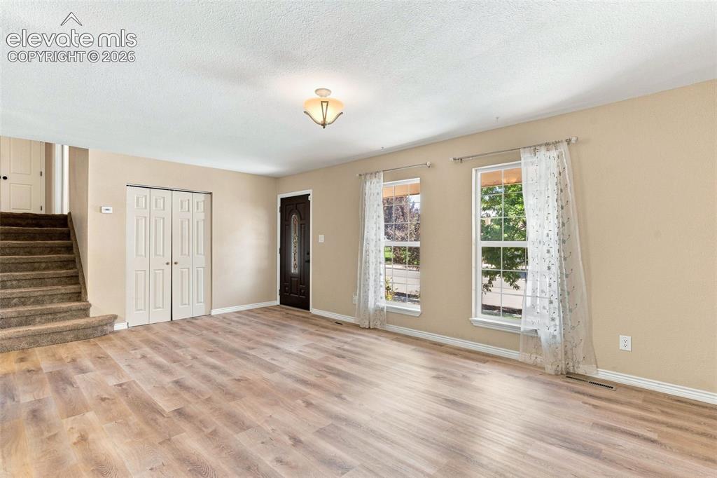Image 17 of 39: The upper level staircase is accessed from the living room.