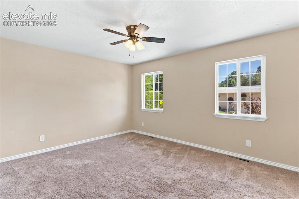 Image 18 of 39: Primary bedroom on upper level features a ceiling fan.