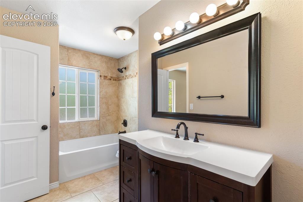 Image 22 of 39: Full bath adjoining primary bedroom and accessible from hallway, boasts a t