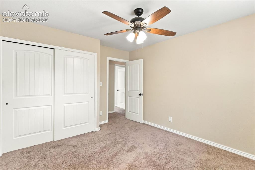 Image 23 of 39: Upper level bedroom 2 features a ceiling fan.