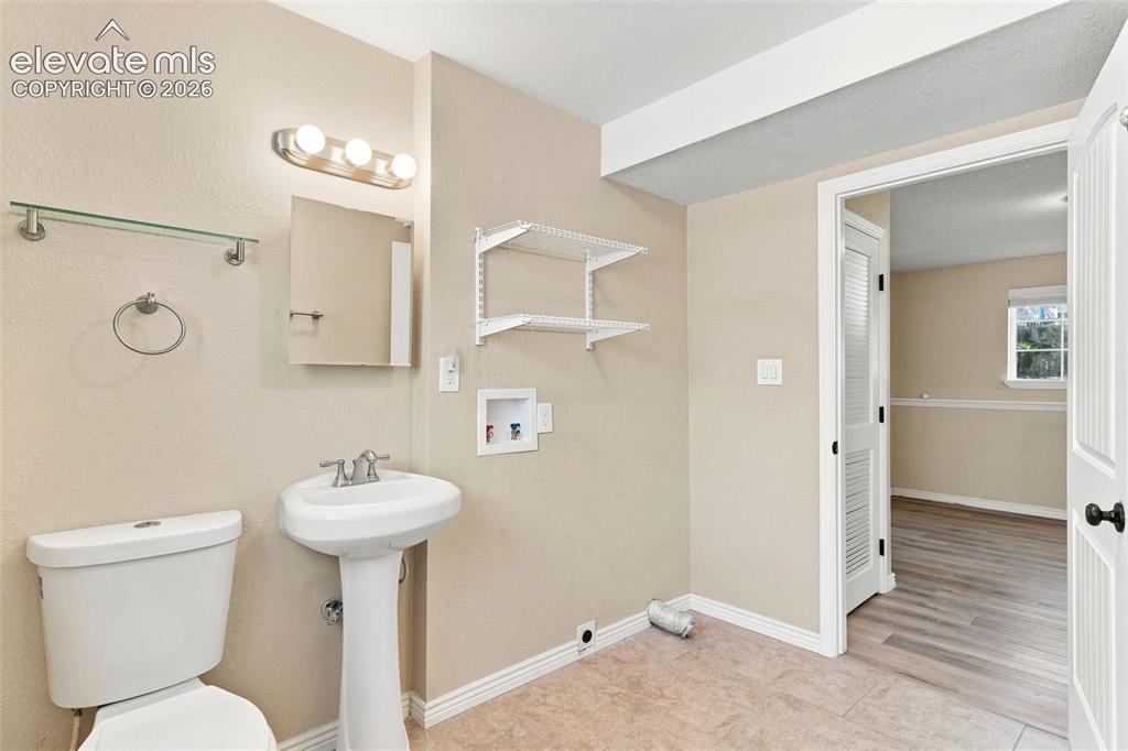 Image 31 of 39: Lower level 3/4 bath AND laundry area is appointed with a tile floor.