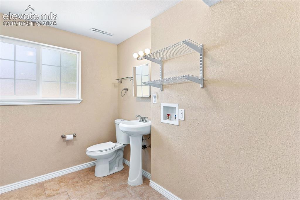 Image 33 of 39: The laundry / 3/4 bath is on the lower level.