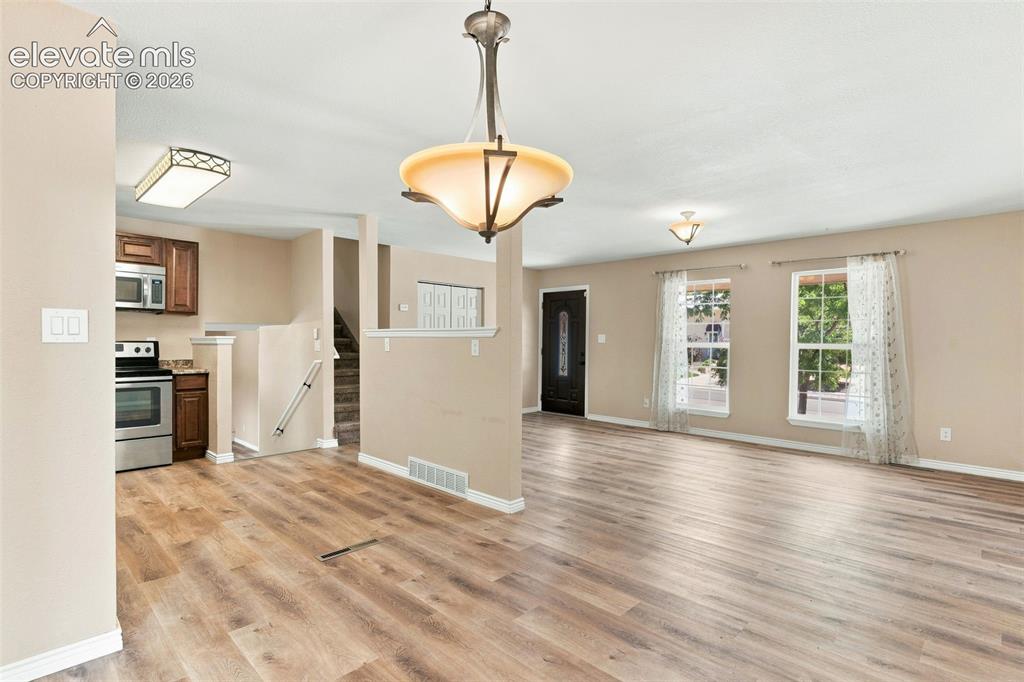 Image 9 of 39: View of the expansive living room and kitchen from the dining area.