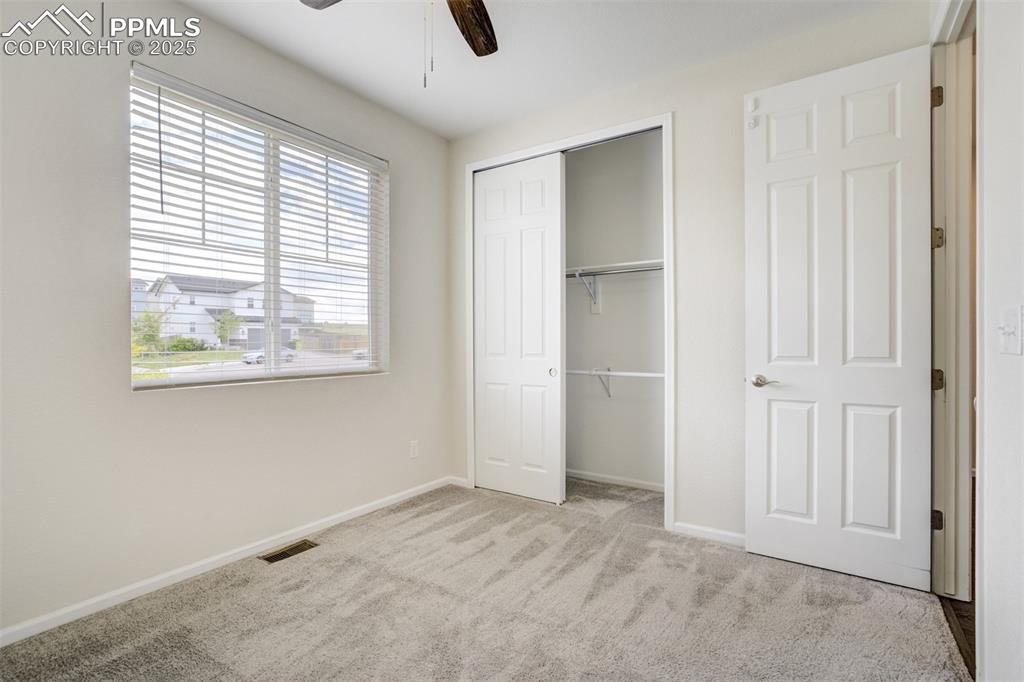 Image 16 of 44: Unfurnished bedroom with carpet, a closet, and a ceiling fan