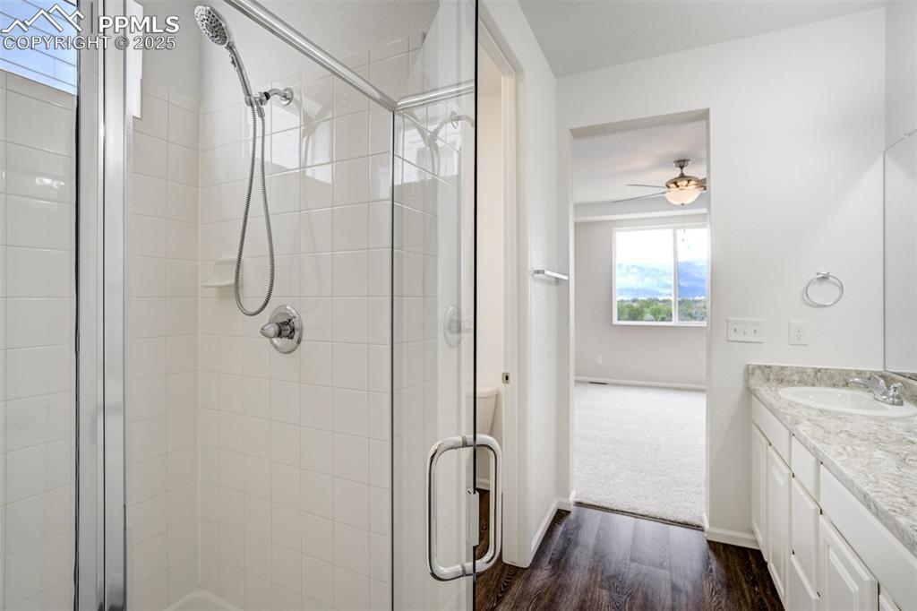Image 24 of 44: Bathroom featuring vanity, a stall shower, wood finished floors, and a ceil