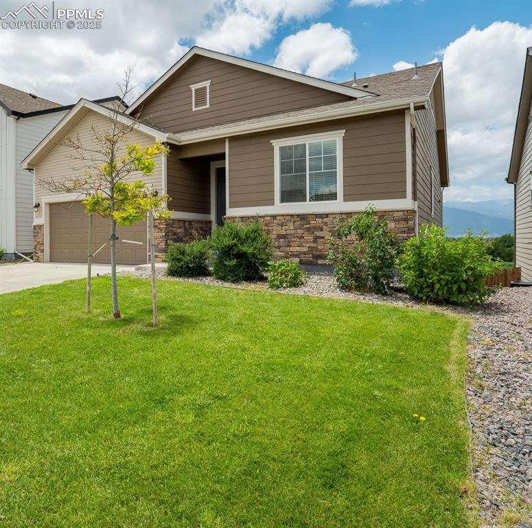 Image 3 of 44: View of front of property featuring a front lawn, concrete driveway, a gara