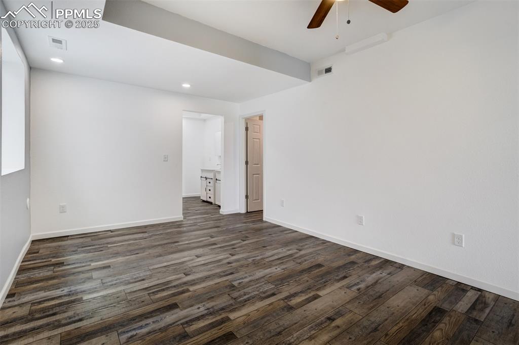 Image 32 of 44: Unfurnished room featuring ceiling fan, dark wood-style floors, and recesse
