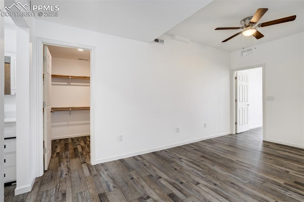 Image 33 of 44: Unfurnished bedroom featuring dark wood finished floors, a spacious closet,