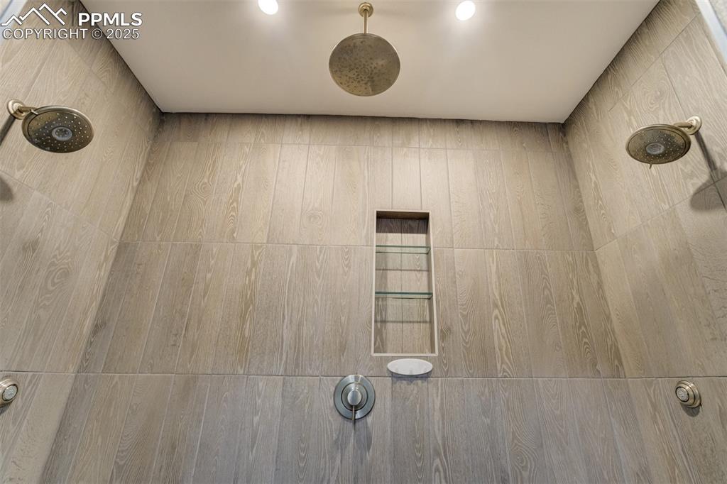 Image 38 of 44: Detailed view of a Rain shower and two additional shower heads and seats