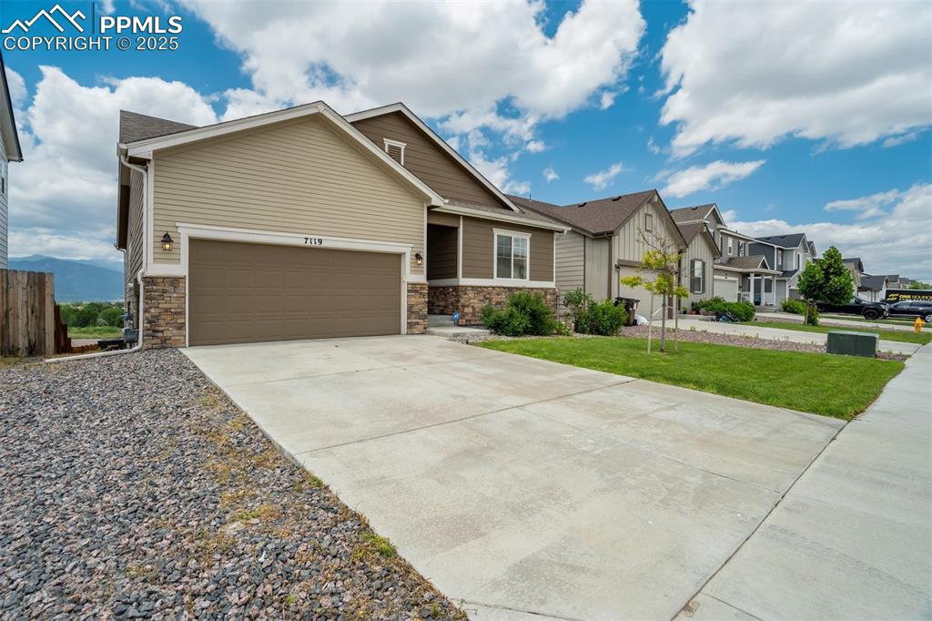 Image 4 of 44: View of front of property featuring a residential view, driveway, stone sid