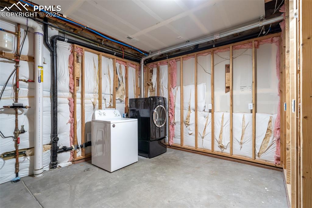 Image 43 of 44: Unfinished basement with washer and clothes dryer