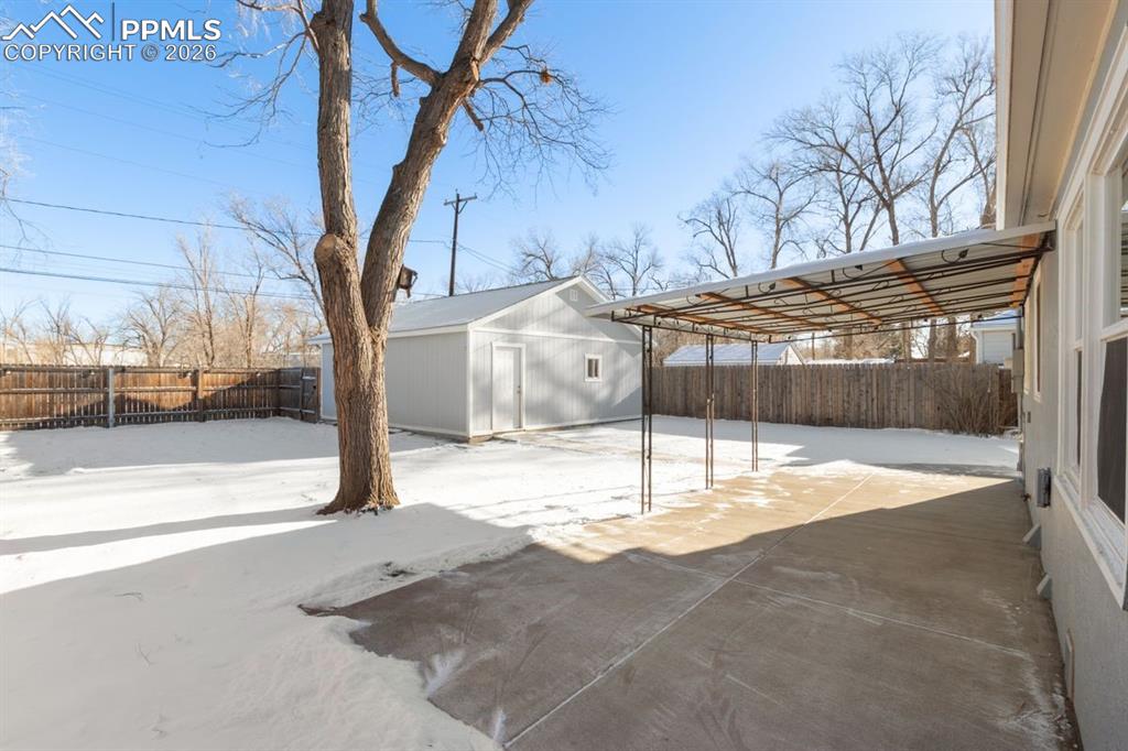 Image 21 of 31: New concrete patio and metal awning.