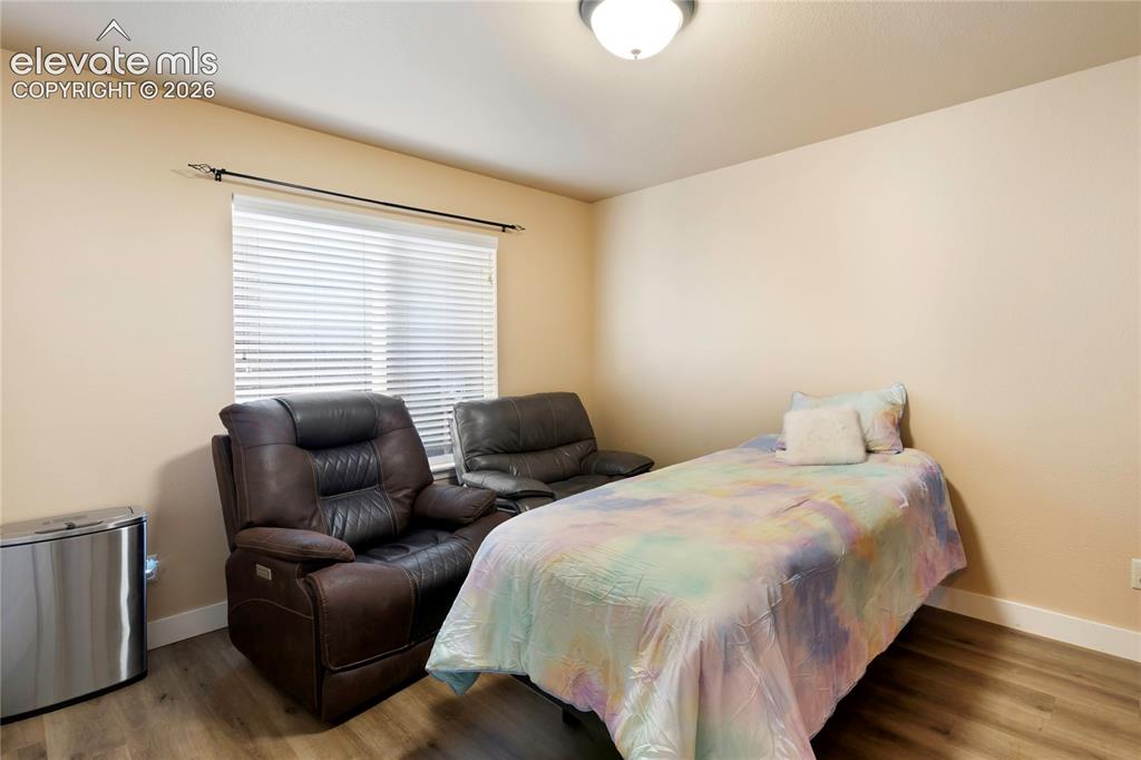 Image 13 of 29: Wood-finish flooring with white trim and a neutral wall color