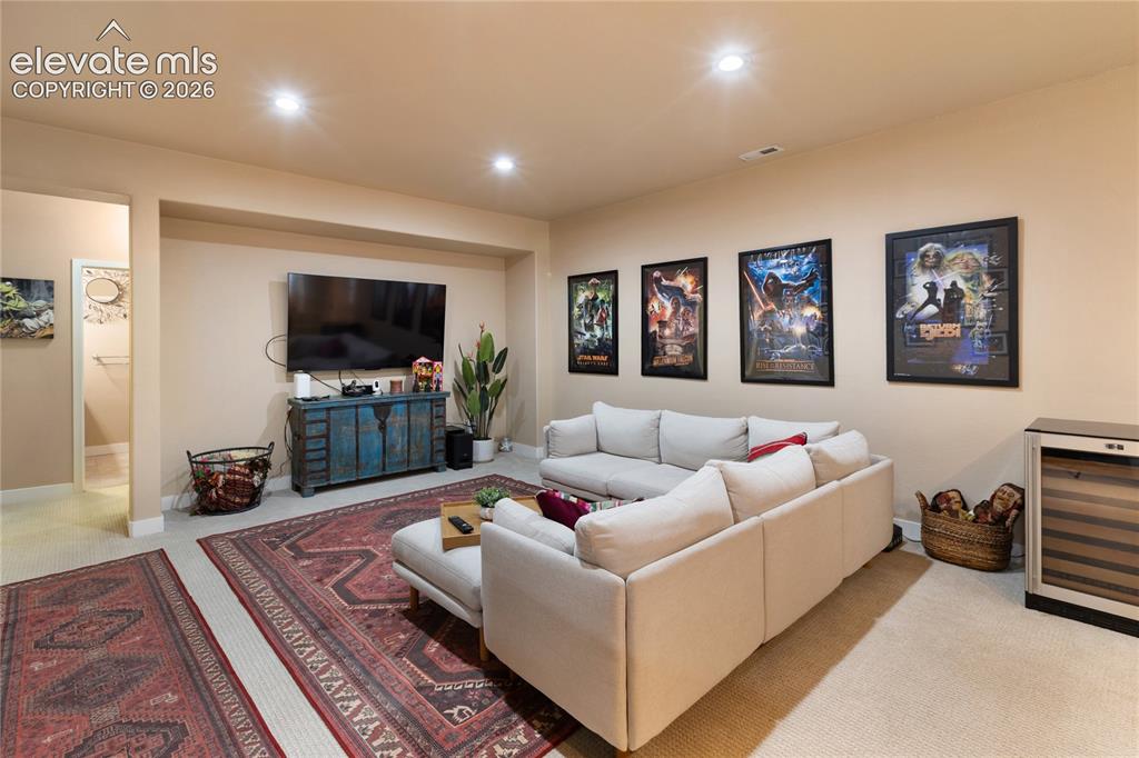Image 15 of 29: Recessed lighting illuminates the open living space with carpet flooring an
