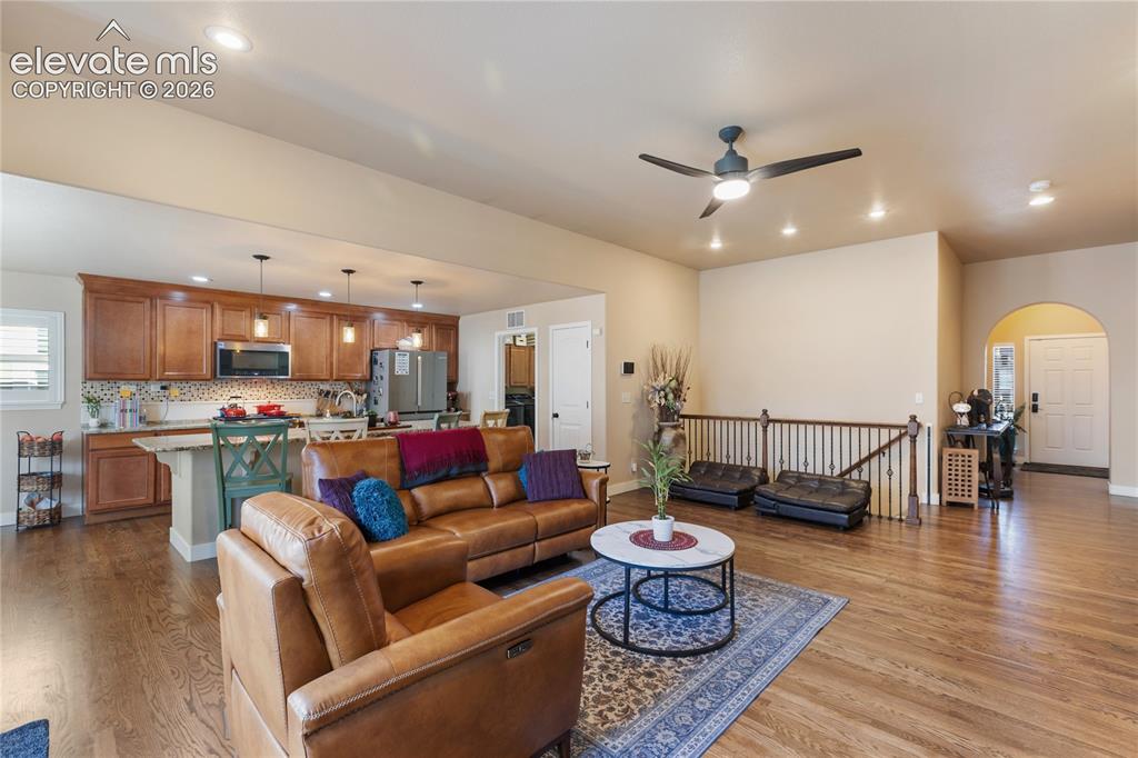 Image 19 of 29: Open-concept living space featuring a wood-finish plank floor, recessed cei