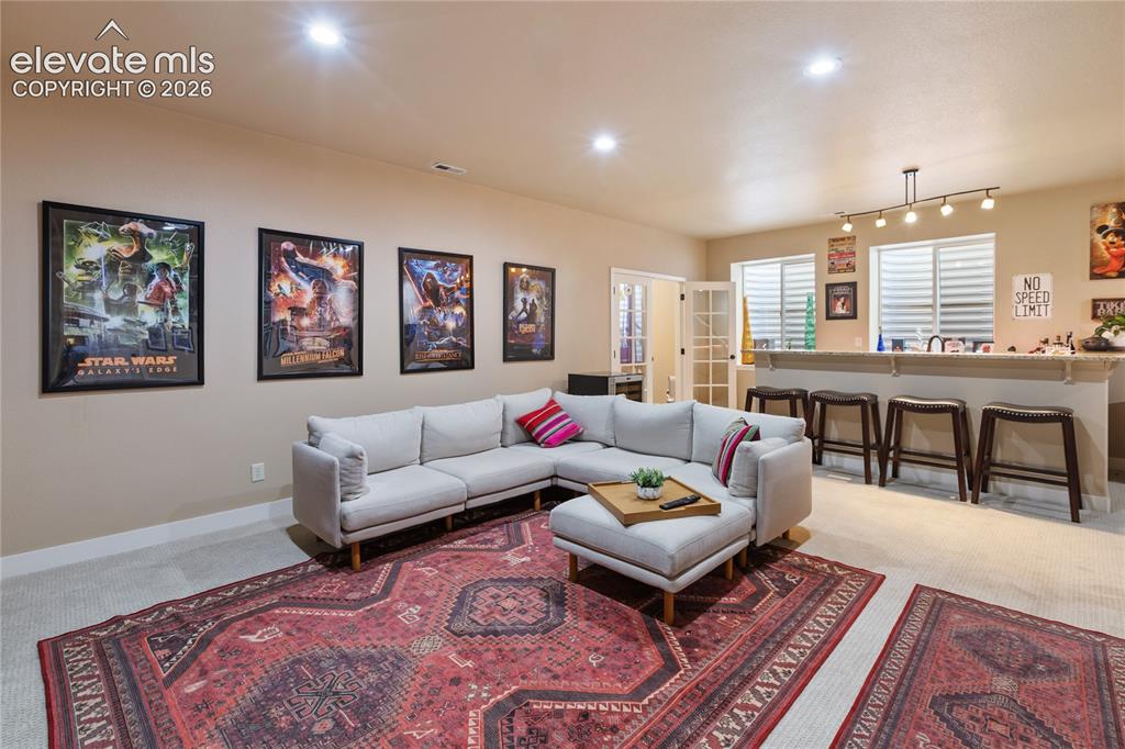 Image 21 of 29: Recessed ceiling lighting, track lighting, built-in bar, French doors, wind