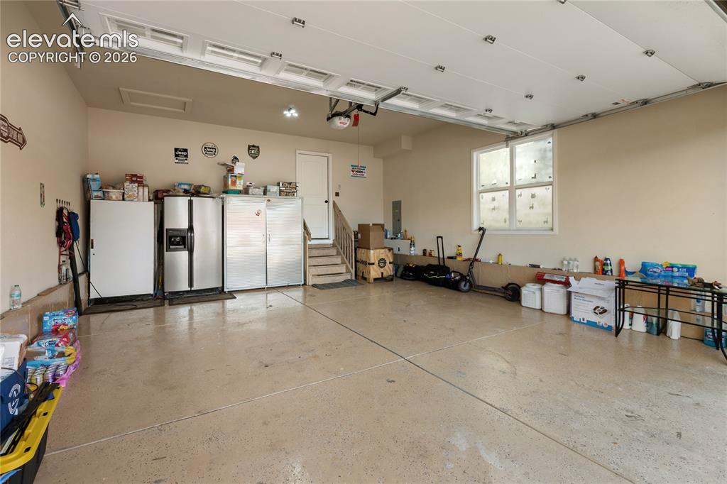 Image 26 of 29: Garage space with an epoxy-finished floor, overhead garage door system, a w