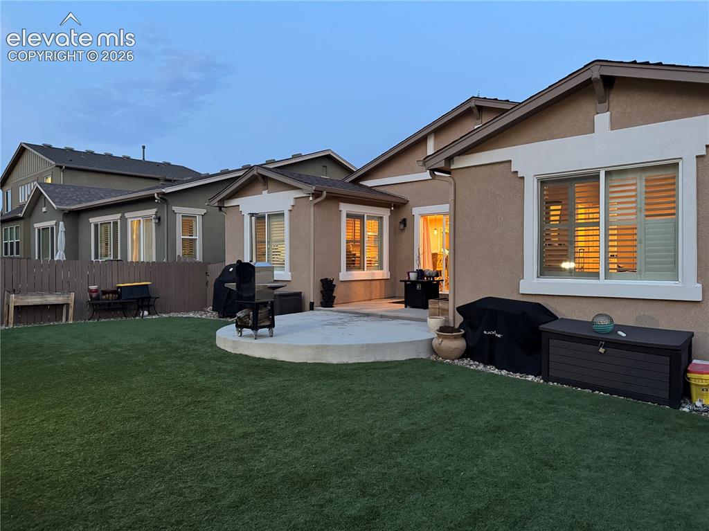 Image 27 of 29: Expansive backyard oasis featuring a circular concrete patio, manicured law