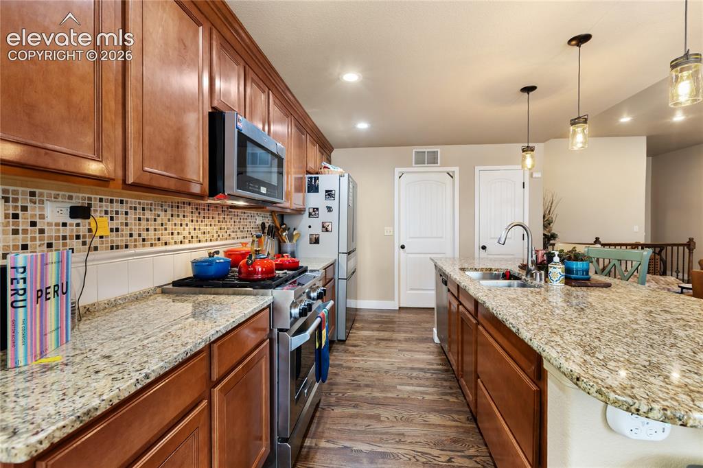 Image 5 of 29: Kitchen featuring wood-finish flooring, full-height cabinetry, stainless st