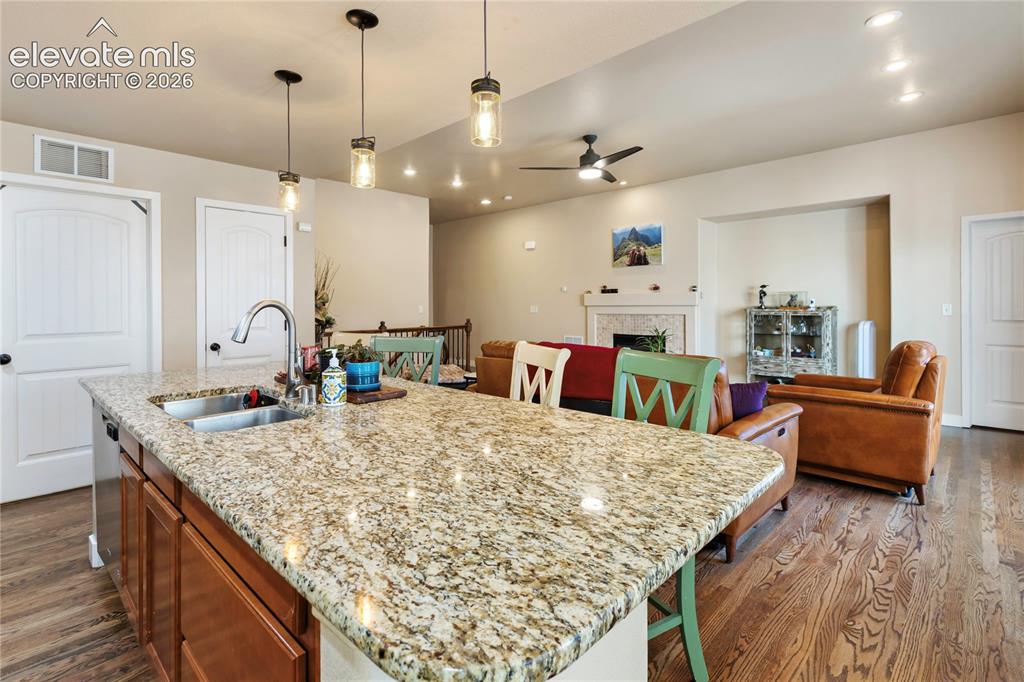 Image 6 of 29: Kitchen island with granite countertop, integrated stainless steel sink, an