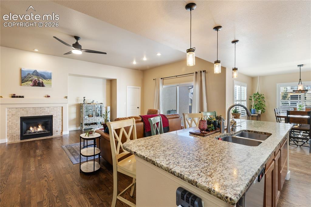 Image 8 of 29: Open-concept living space with wood-finish flooring, a kitchen island featu