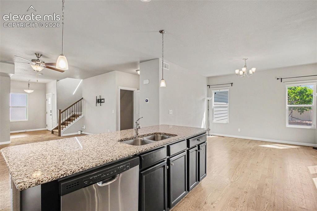 Image 12 of 39: Kitchen island featuring granite-finish countertop, double basin sink, and