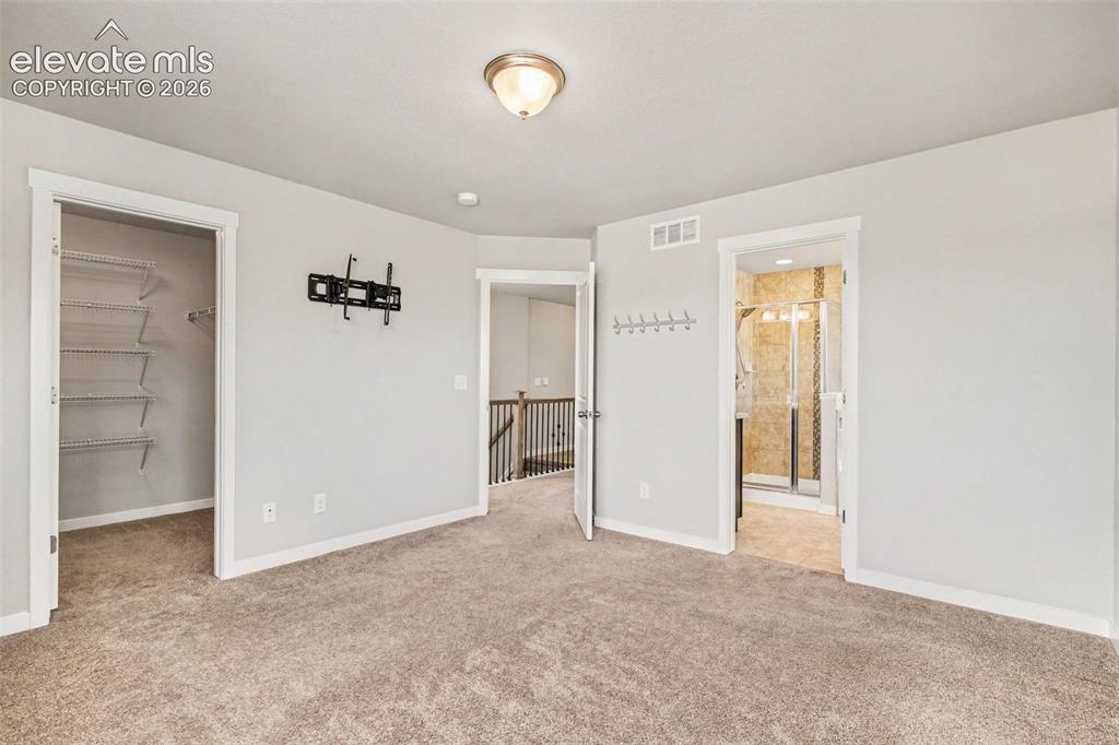 Image 18 of 39: Expansive carpeted room featuring a ceiling-mounted light fixture and light