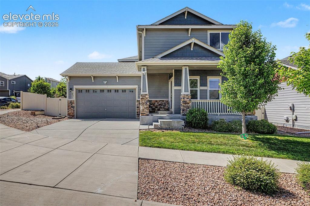 Image 2 of 39: Two-story residence featuring a covered front porch, an attached two-car ga