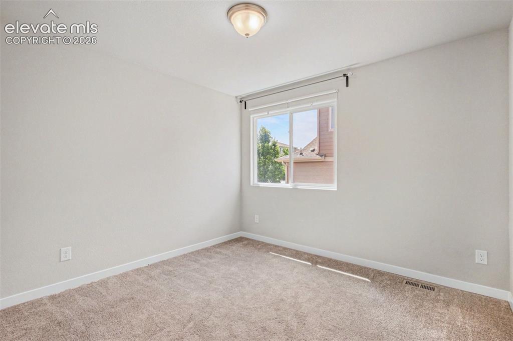 Image 24 of 39: Light-filled room featuring neutral wall paint, a double window with blinds