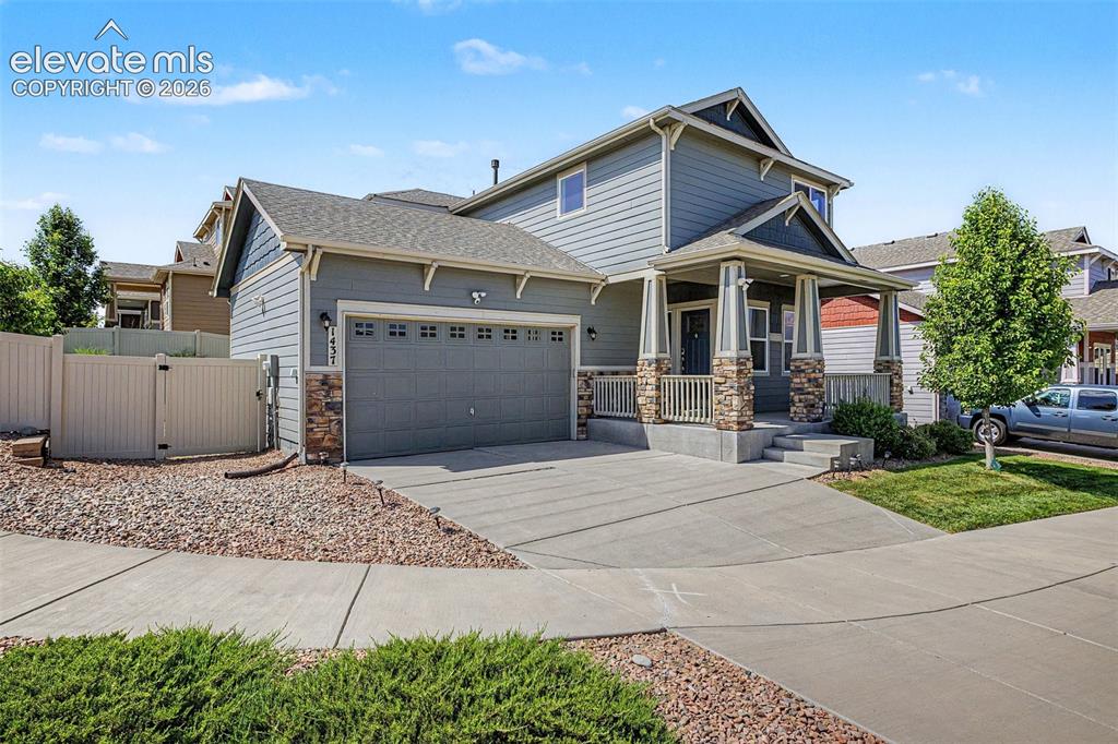 Image 3 of 39: Two-story residence featuring a covered front porch with stone accents, a t