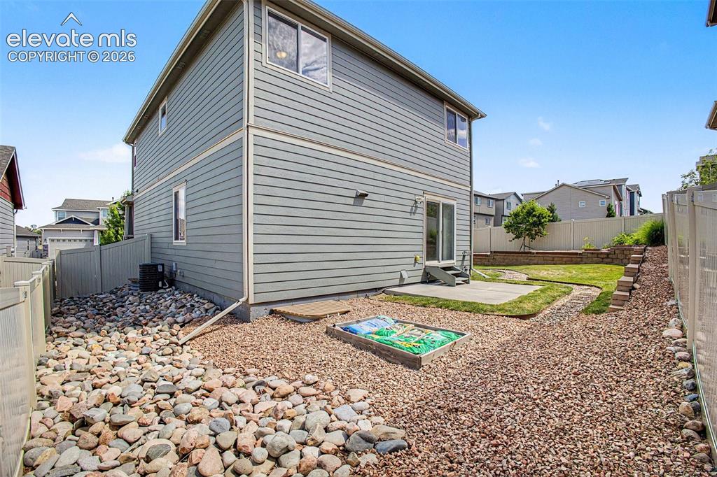 Image 34 of 39: Rear exterior featuring gray siding, a concrete patio, a sliding glass door