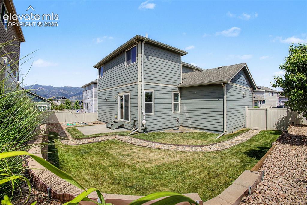 Image 36 of 39: Rear exterior featuring horizontal siding, a gabled roofline, and multiple