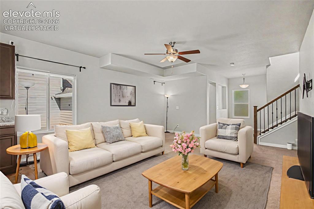 Image 5 of 39: Virtually Staged - Living space featuring a tray ceiling with a ceiling fan