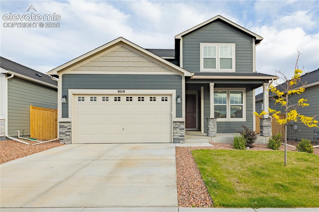 Image 1 of 30: Two-story exterior with siding and stone accents, covered front porch, atta
