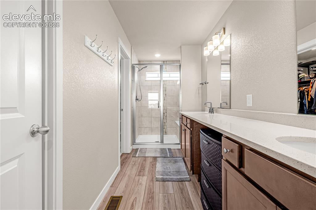 Image 11 of 30: Dual vanity with light-colored countertops