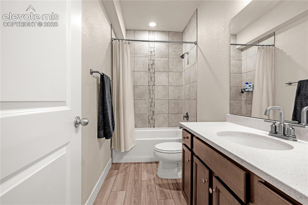 Image 12 of 30: Wood-finish flooring, a spacious vanity with dual sinks and a light-toned c
