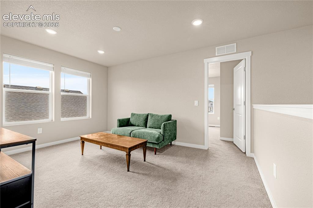 Image 14 of 30: Recessed lighting, light-toned carpeting, multiple windows with blinds, and