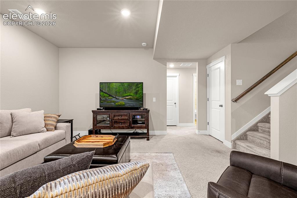 Image 18 of 30: Recessed lighting, light-toned carpeting, panel doors, and a wood-finish st