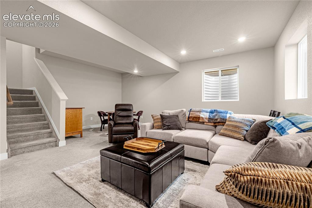 Image 19 of 30: Carpeted living space featuring recessed lighting and a window with blinds