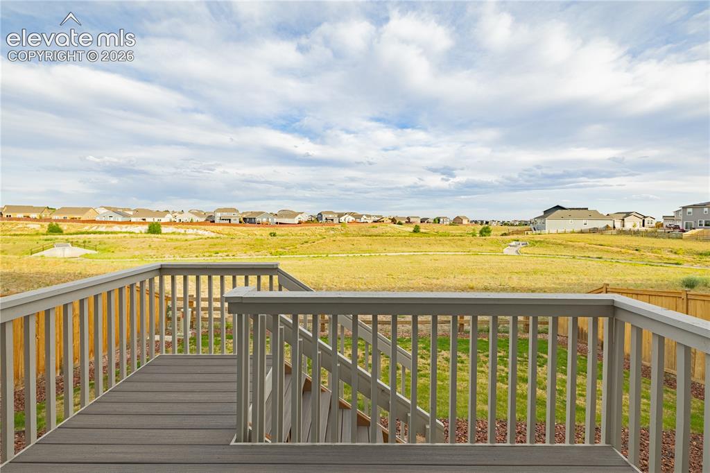 Image 24 of 30: Expansive deck featuring composite decking and painted railings, with steps