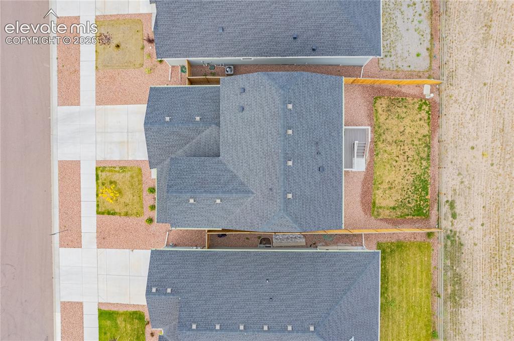 Image 27 of 30: Single-family residence with a dark shingle roof, accompanied by an adjacen